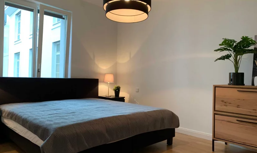 Decorated bedroom with bed, wooden table and plant