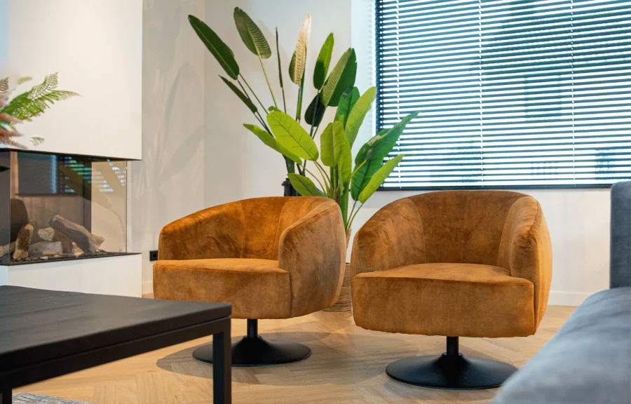 Two orange chairs in front of a plant