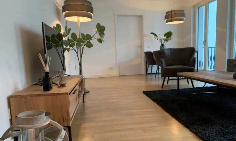 A cozy living room,  featuring a TV, furniture, a table, and chairs