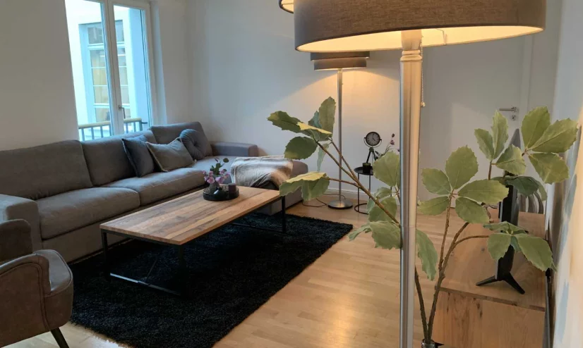 A well-furnished living room with a couch, coffee table, and a decorative lamp