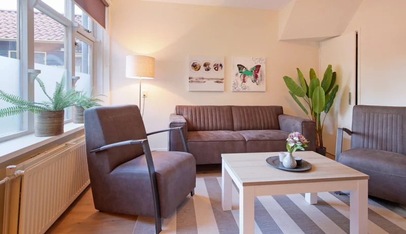 Cozy living room with full interior. Couchm chairs and coffee table.