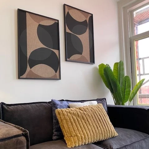 Artwork hanging above a black couch